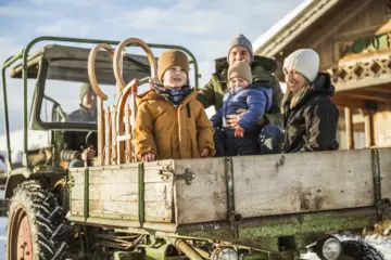 Familienurlaub im Winter mit Schlittenfahren im Schnee